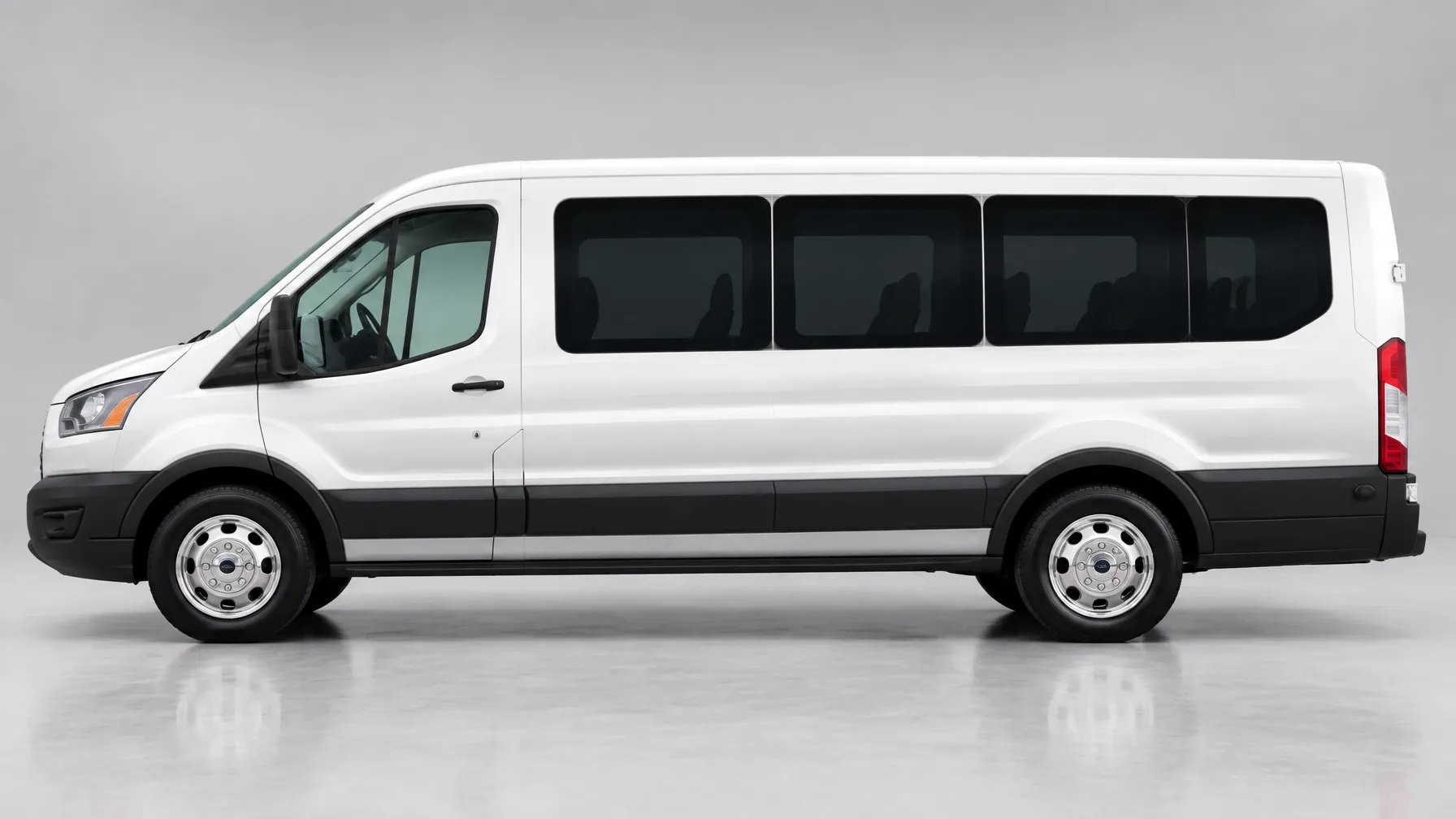 White 2023 Ford Transit 11-passenger van in side profile on a light gray studio backdrop for passenger group rental